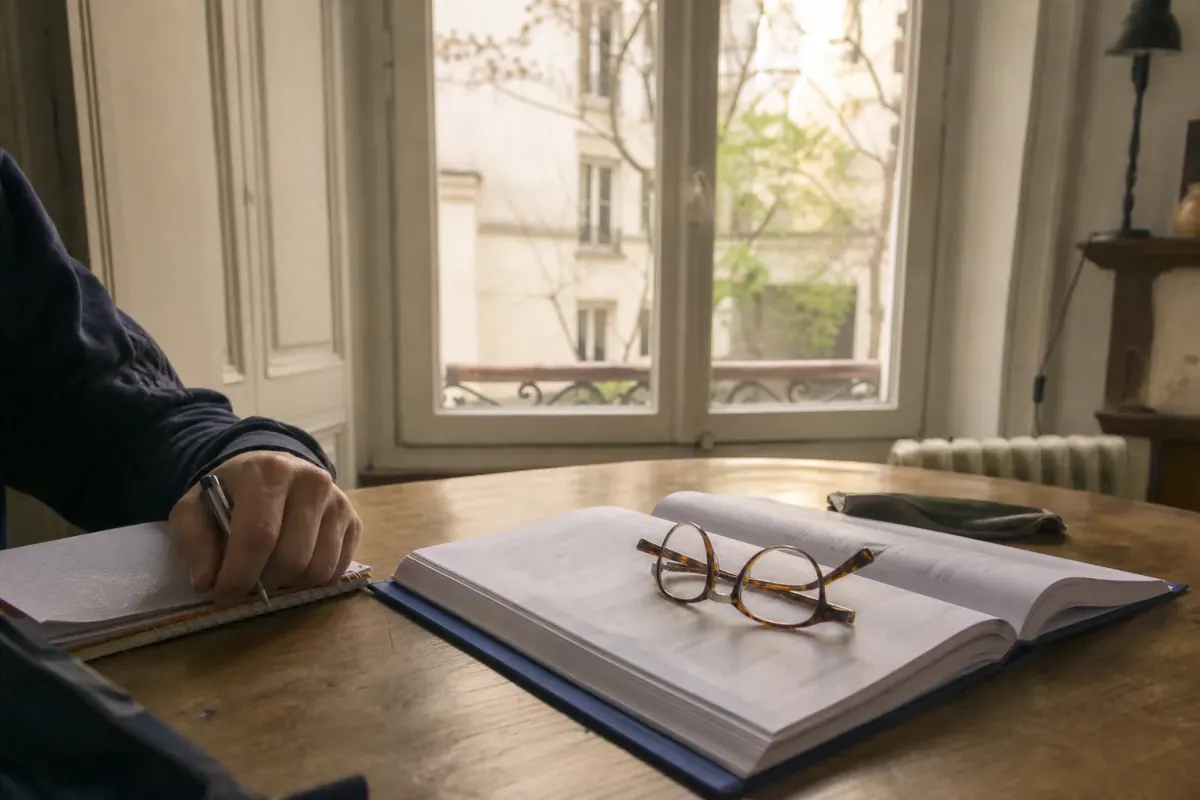 Copropriétaire relisant le règlement de copropriété et la loi de 1965 avant une décision de travaux