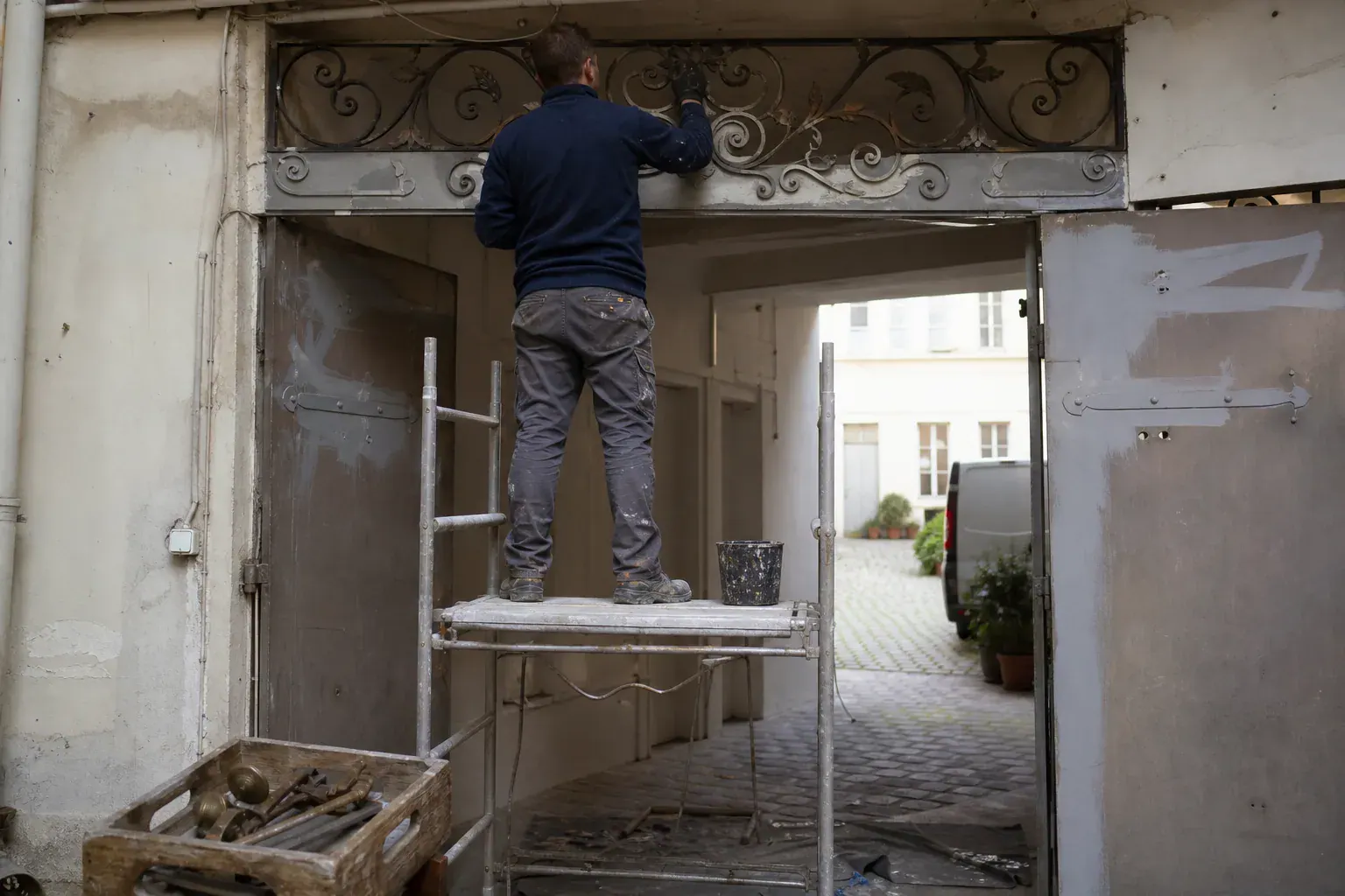 Pentures et imposte en fer d’une porte cochère brossées avant antirouille, quincaillerie déposée