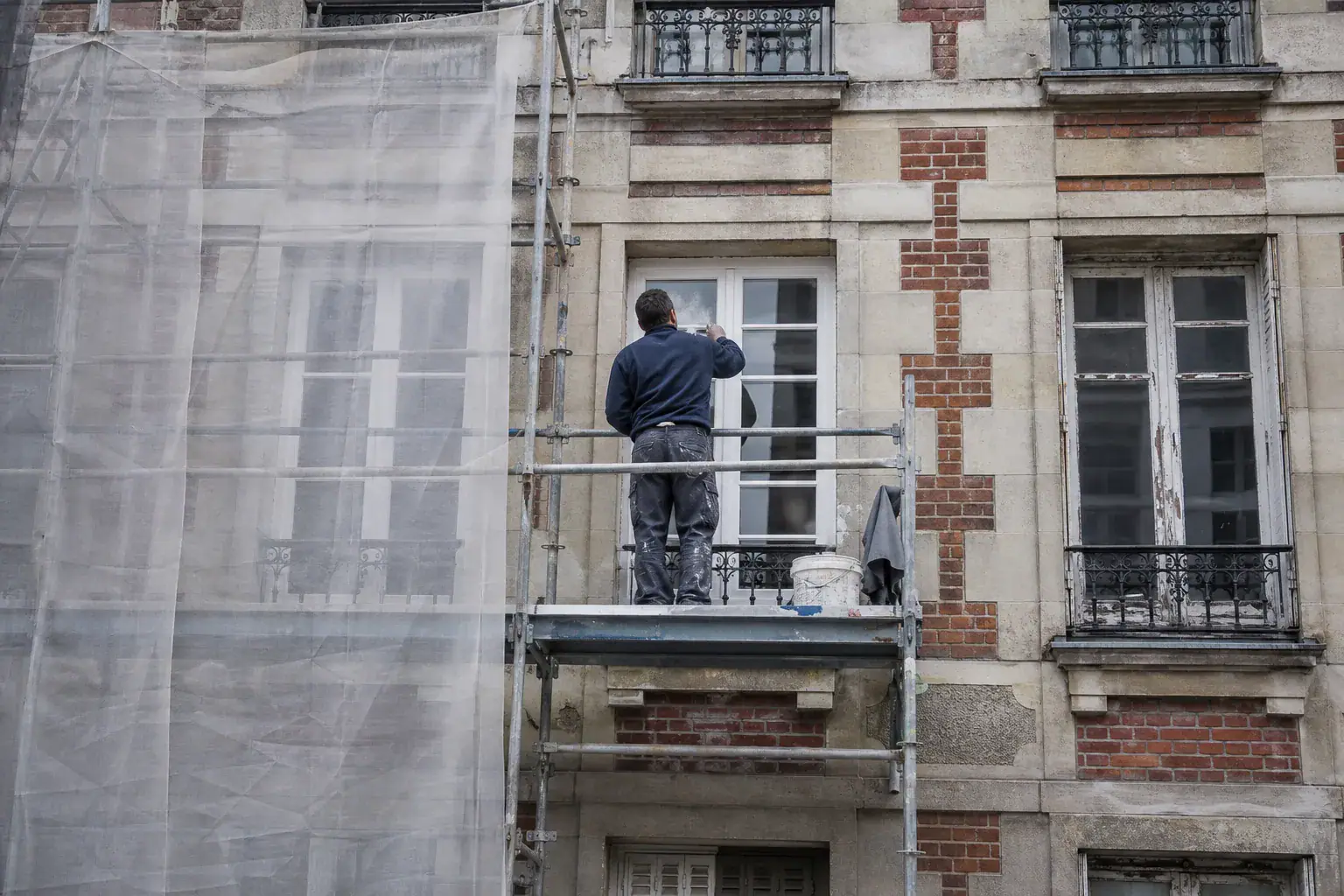 Fenêtres en bois d’un immeuble en brique des Hauts-de-Seine reprises au mastic et repeintes
