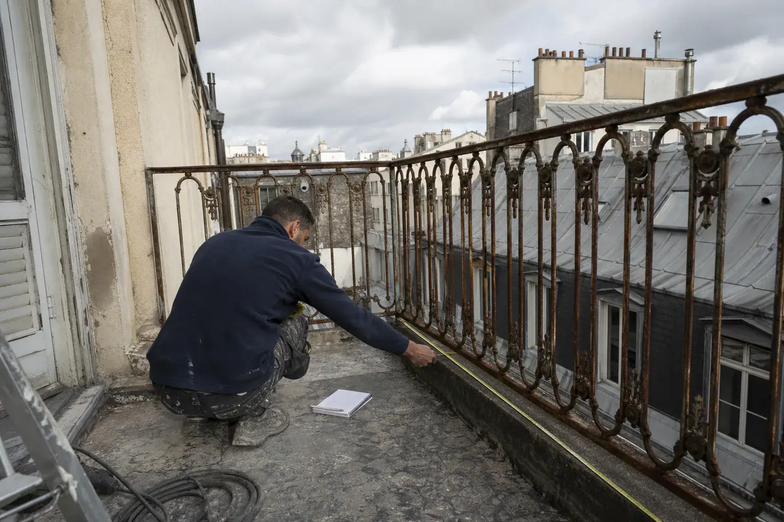 Mesure au mètre linéaire d’un garde-corps en fer rouillé avant devis de remise en peinture