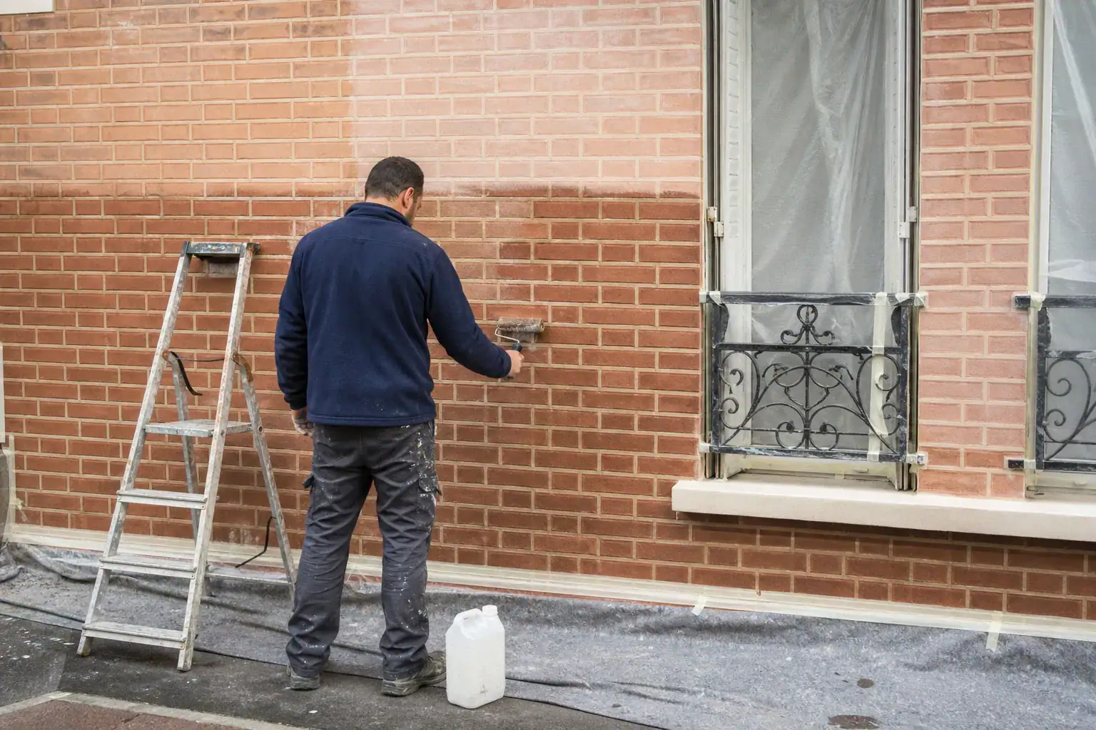 Traitement préventif anti-graffiti appliqué sur une façade en brique propre