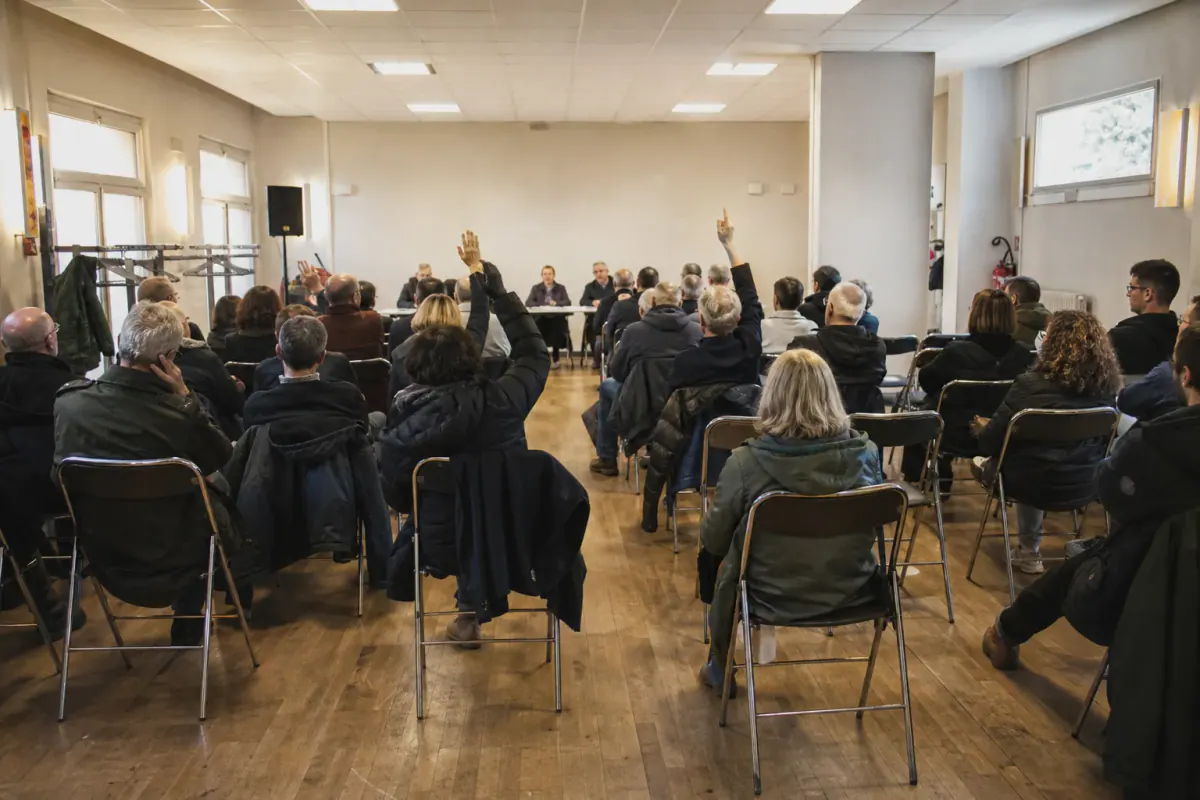 Copropriétaires levant la main lors du vote des travaux de peinture en assemblée générale